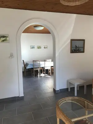 a living room with a table and a dining room at Townhouse centrally located close to Jesperhus in Nykøbing Mors