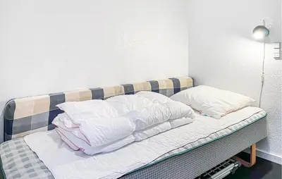 a bed with white sheets and pillows on it at Amazing Home In Vestervig With Sauna in Vestervig