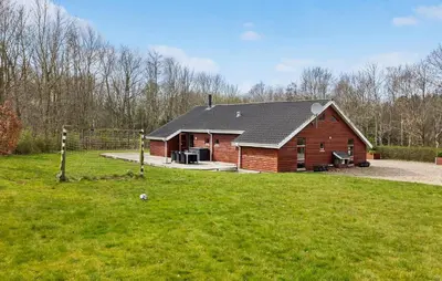 a barn with a gambrel roof on a grass field at Cozy Home In Spøttrup With Sauna in Spottrup