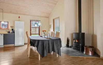 a dining room with a table and a stove at Cozy Home In Spøttrup With Sauna in Spottrup