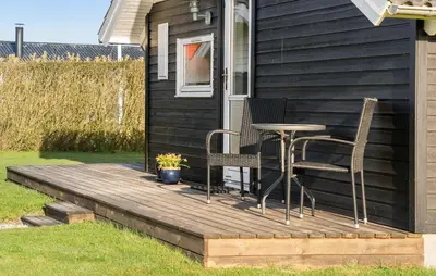 a wooden deck with chairs and a table on a house at Gorgeous Home In Vinderup With Sauna in Vinderup