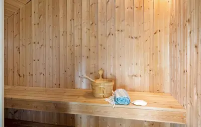 a wooden shelf in a sauna with a bucket at Gorgeous Home In Vinderup With Sauna in Vinderup