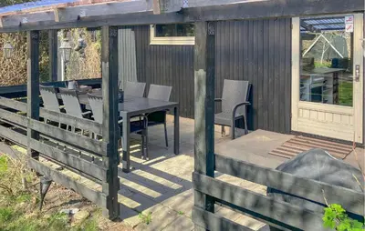 a wooden deck with a table and chairs on it at 4 Bedroom Amazing Home In Hurup Thy in Sønder Ydby