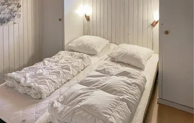 two unmade beds in a small room with at 4 Bedroom Amazing Home In Hurup Thy in Sønder Ydby