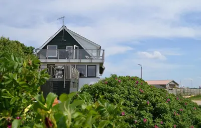 a house with a balcony on the beach at Nice Home In Øster Assels in Øster Assels