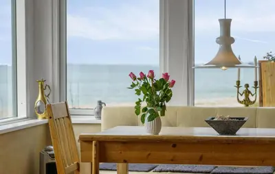a dining room table with a vase of flowers on it at Nice Home In Øster Assels in Øster Assels