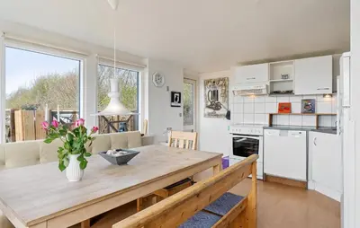 a kitchen and dining room with a wooden table at Nice Home In Øster Assels in Øster Assels