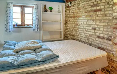 a bed in a room with a brick wall at 1 Bedroom Gorgeous Home In Spøttrup in Spottrup