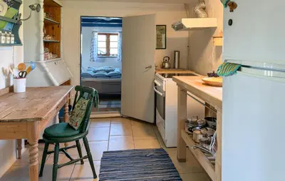 a kitchen with a wooden table and a green chair at 1 Bedroom Gorgeous Home In Spøttrup in Spottrup