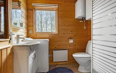 a bathroom with a toilet and a sink and a window at 3 Bedroom Stunning Home In Spøttrup in Spottrup