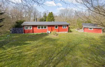 a red house in the middle of a field at 3 Bedroom Stunning Home In Spøttrup in Spottrup