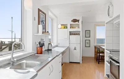 a white kitchen with a sink and a refrigerator at 2 Bedroom Stunning Home In Øster Assels in Øster Assels