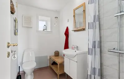 a white bathroom with a toilet and a sink at 2 Bedroom Stunning Home In Øster Assels in Øster Assels