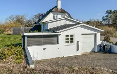 a white garage with a window and a house at Stunning Home In Fjerritslev With Sauna in Fjerritslev