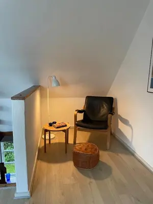 a living room with a chair and a table at Surfreservatet i Nationalpark Thy in Hanstholm