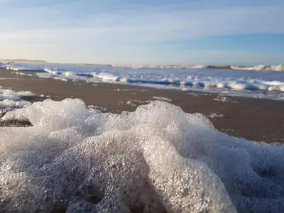 a pile of snow on a beach near the ocean at 4 star holiday home in Brovst in Brovst