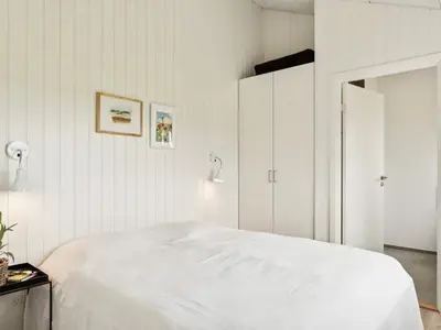 a white bedroom with a bed and a closet at 5 star holiday home in Løkken in Løkken