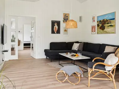 a living room with a black couch and a table at 5 star holiday home in Løkken in Løkken