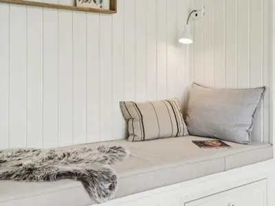a bed in a room with a pillow and a blanket at 5 star holiday home in Løkken in Løkken