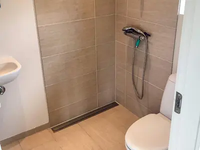 a bathroom with a shower with a toilet and a sink at 4 star holiday home in Brovst in Brovst