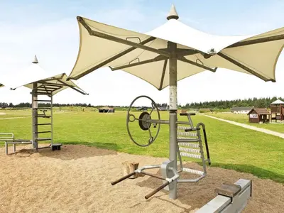 a playground with a white umbrella and a swing at 4 star holiday home in Brovst in Brovst