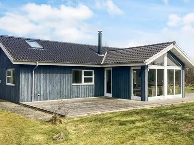 a blue house with a porch and a deck at 4 star holiday home in Brovst in Brovst
