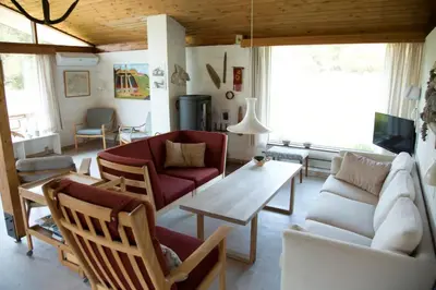 a living room with a couch and a table at Dune House Near Bulbjerg in Frøstrup