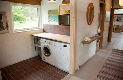 a washer and dryer in a tiny house at Dune House Near Bulbjerg in Frøstrup