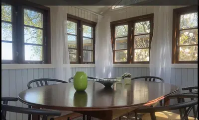 a dining room table with chairs and a green vase on it at PipOp - the place where you find your soul again in Struer