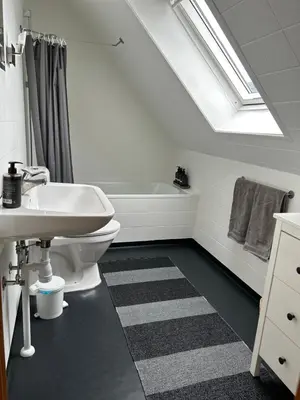 a bathroom with a sink and a bath tub at Bright Nordic Loft Apartment in Spottrup