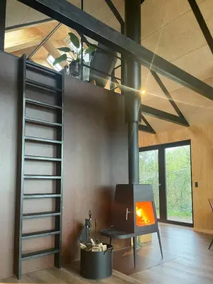 a living room with a fireplace in a house at Modern Wooden House Near Halkær Bredning in Nibe