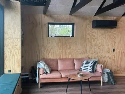 a living room with a couch and a table at Modern Wooden House Near Halkær Bredning in Nibe