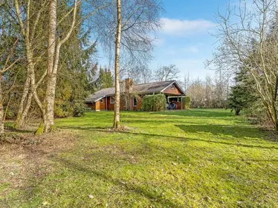 a house in the middle of a field with trees at Holiday Home Franzisca - 200m to the fjord by Interhome in Roslev