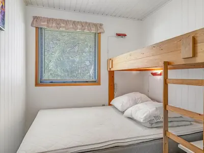a small bedroom with a bunk bed and a window at Holiday Home Franzisca - 200m to the fjord by Interhome in Roslev