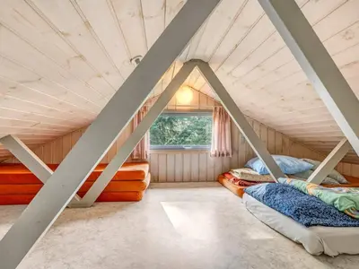 a room with three bunk beds in a attic at Holiday Home Franzisca - 200m to the fjord by Interhome in Roslev