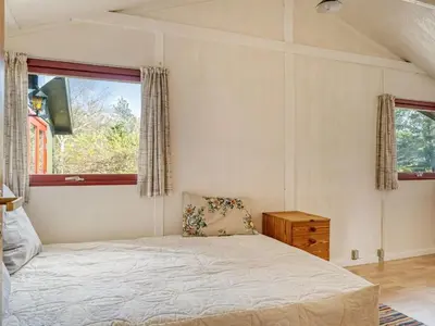 a bedroom with a bed and a window at Holiday Home Nimrod - 800m from the sea by Interhome in Blokhus