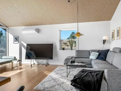 a living room with a couch and a tv at Holiday Home Heidl - 2km from the sea by Interhome in Blokhus