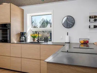 a kitchen with a large clock on the wall at Holiday Home Heidl - 2km from the sea by Interhome in Blokhus
