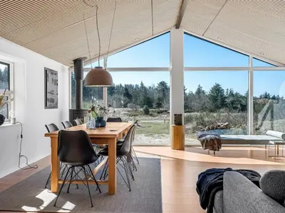 a dining room and living room with a table and chairs at Holiday Home Heidl - 2km from the sea by Interhome in Blokhus