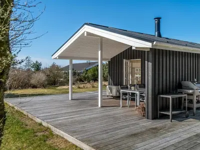 a pavilion with tables and chairs on a wooden deck at Holiday Home Jork - 1km from the sea by Interhome in Saltum