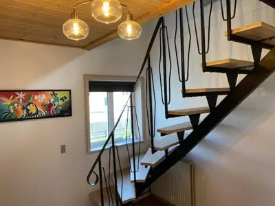 a staircase in a house with lights and a window at Dejlig gårdhave 5 soveværelser in Harboør
