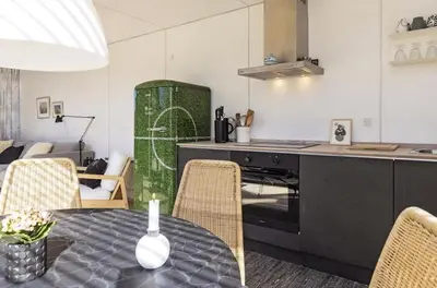 a kitchen with a table and chairs and a kitchen with a stove at Modern Holiday Home By Limfjord in Øster Assels