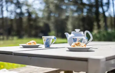 a table with two cups and plates of food on it at 3 Bedroom Pet Friendly Home In Løkken in Løkken