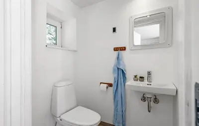a white bathroom with a toilet and a sink at 3 Bedroom Pet Friendly Home In Løkken in Løkken