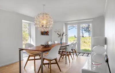 a dining room with a table and chairs and a chandelier at 3 Bedroom Pet Friendly Home In Løkken in Løkken