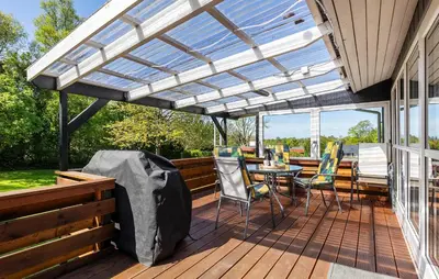 a pergola on a deck with a table and chairs at 3 Bedroom Nice Home In Farsø in Farsø