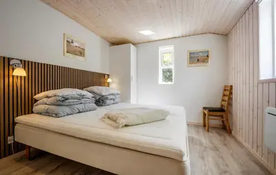 a bedroom with a bed with four pillows on it at 3 Bedroom Nice Home In Farsø in Farsø