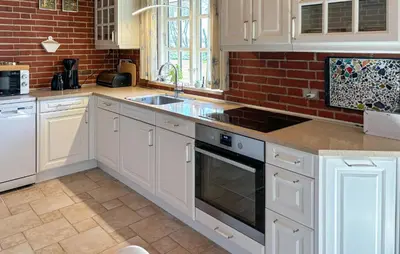 a kitchen with white cabinets and a brick wall at Nice Home In Roslev With Wifi in Roslev