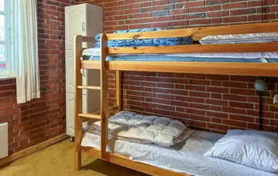 a room with two bunk beds in a brick wall at Nice Home In Roslev With Wifi in Roslev