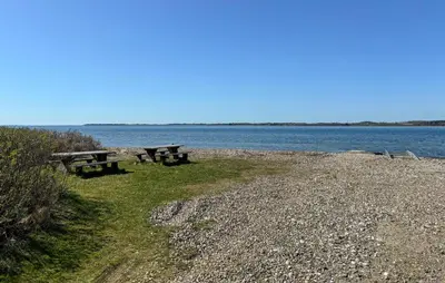 two picnic tables on the shore of a body of water at Nice Home In Roslev With Wifi in Roslev